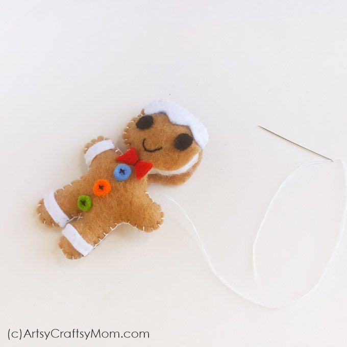 This Felt Gingerbread Man Christmas Ornament is as cute a button and pretty simple to make! Hang it on your tree or gift it to a special friend!