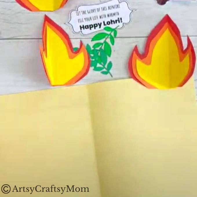 Cut out some logs from brown craft paper and fold it in half Stick logs on middle crease