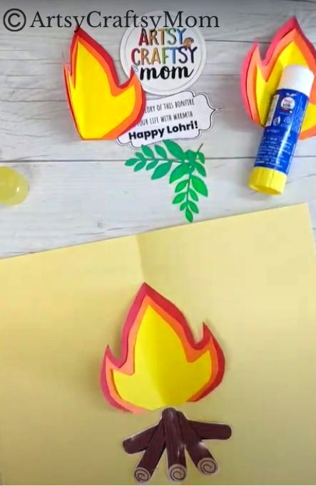 Cut out some logs from brown craft paper and fold it in half Stick logs on middle crease